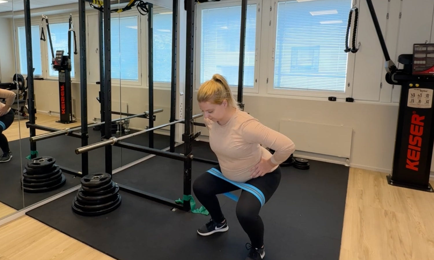 raskaana oleva nainen tekee lihaskuntoliikkeitä