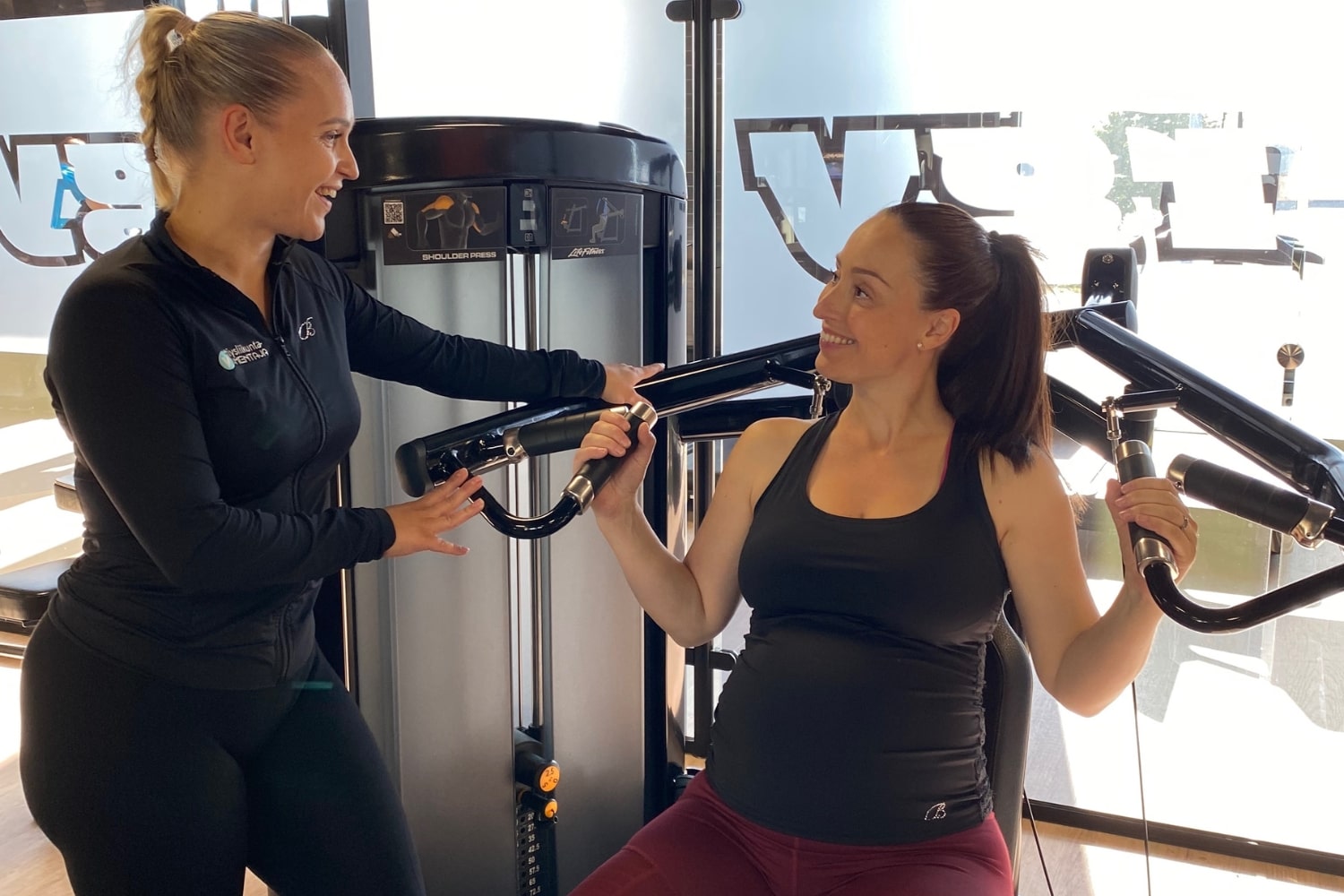 Personal trainer ohjaamassa raskaana olevaa asiakasta