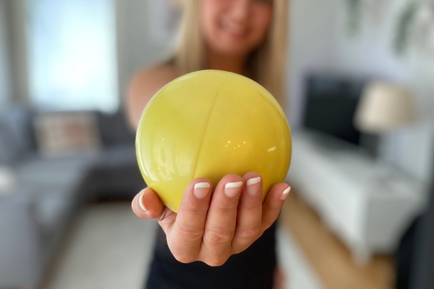 Nainen ojentaa palloa lantionpohjan lihakset rentoutusharjoitukseen