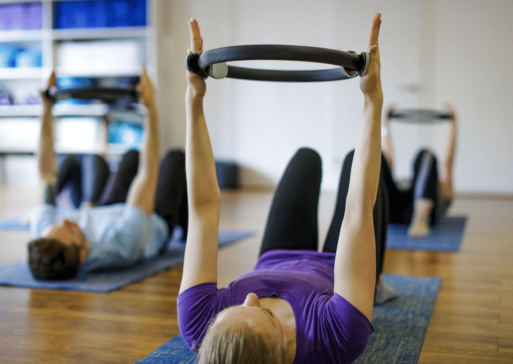 Kuva pilates tunnista, jossa käytössä apuvälineenä pilatesrengas. 